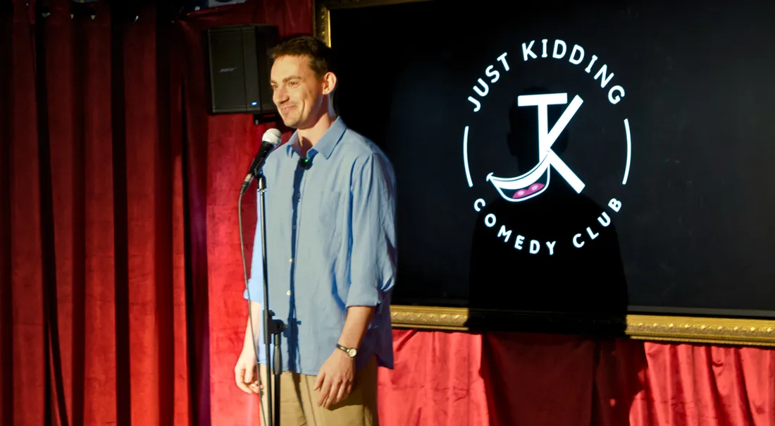 Comedian performing live stand-up on stage at JK Comedy Club Leicester Square on a Saturday night